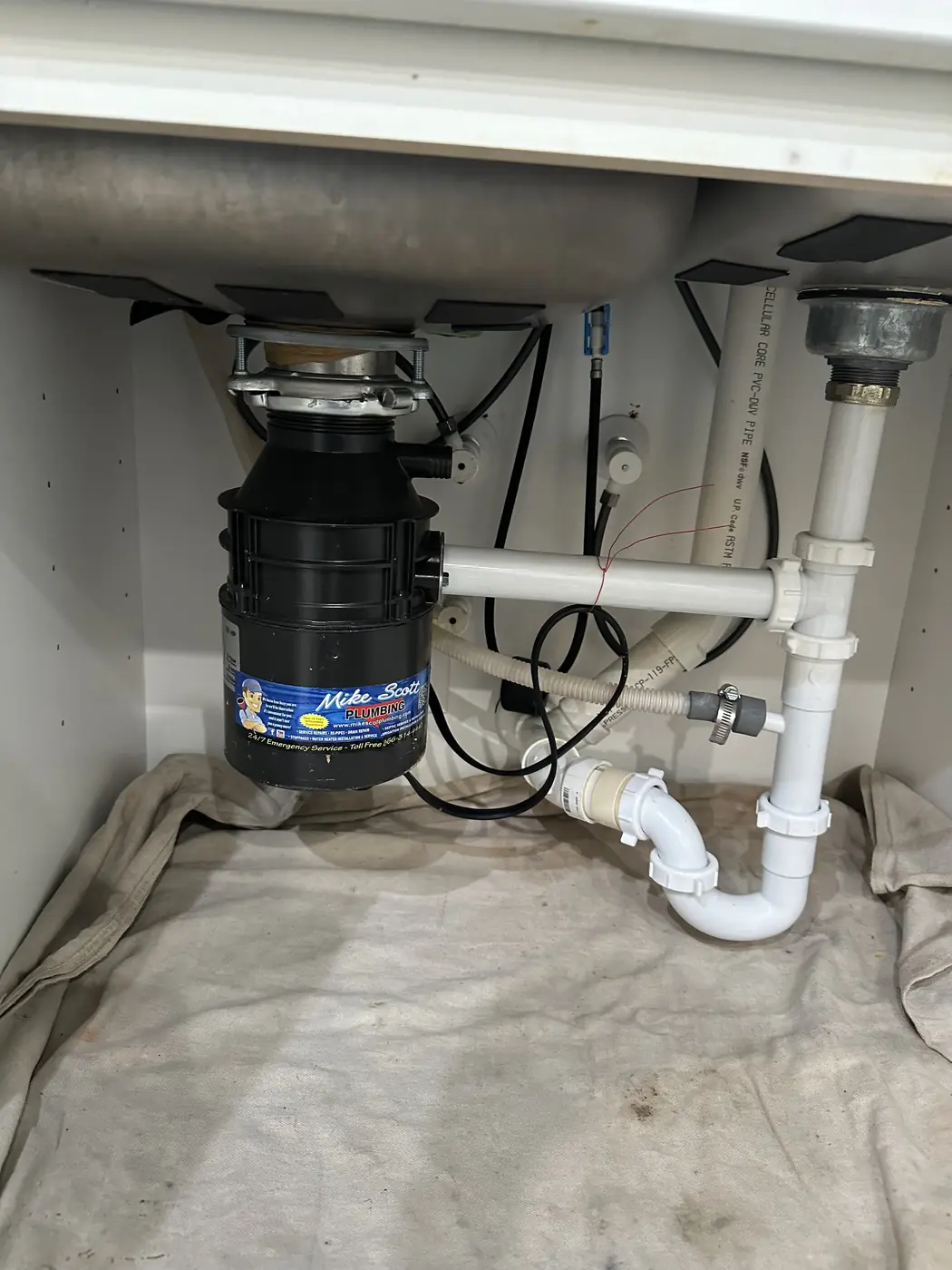 New garbage disposal and drain under a sink